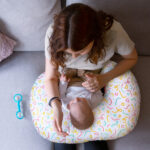 New Mom holding baby on fresh hug freshug Doodle Hug Nursing Pillow