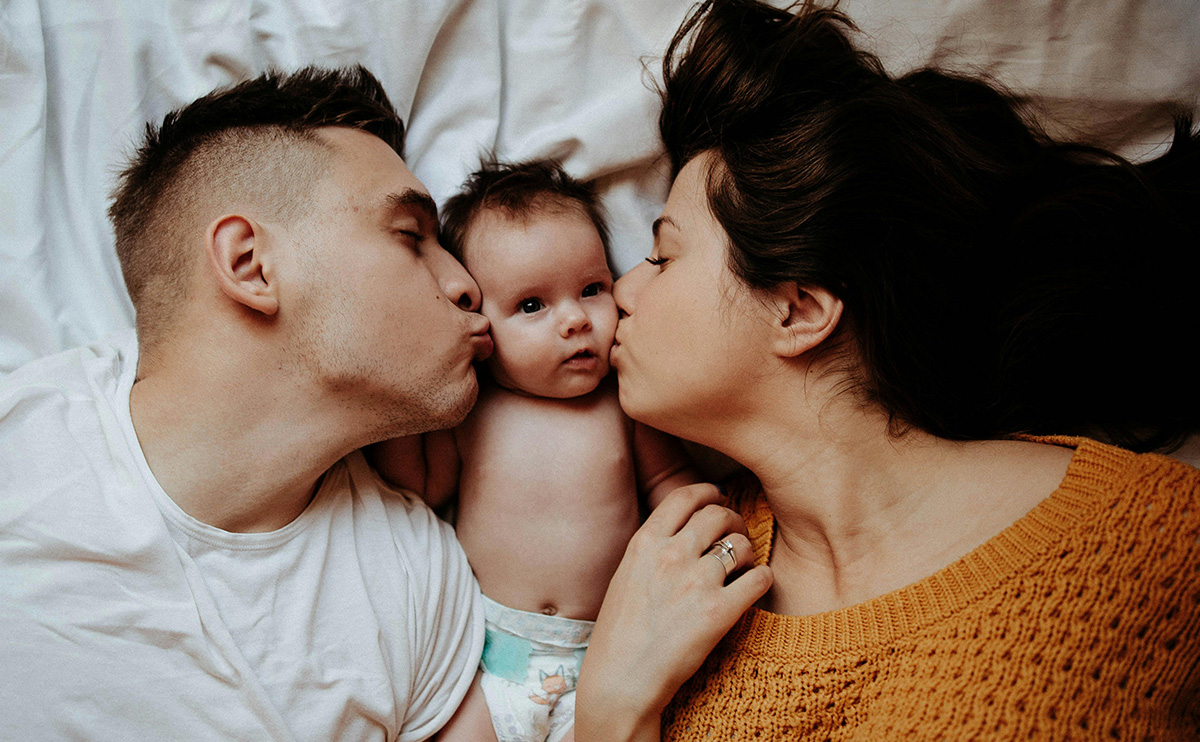 parent kissing their newborn baby