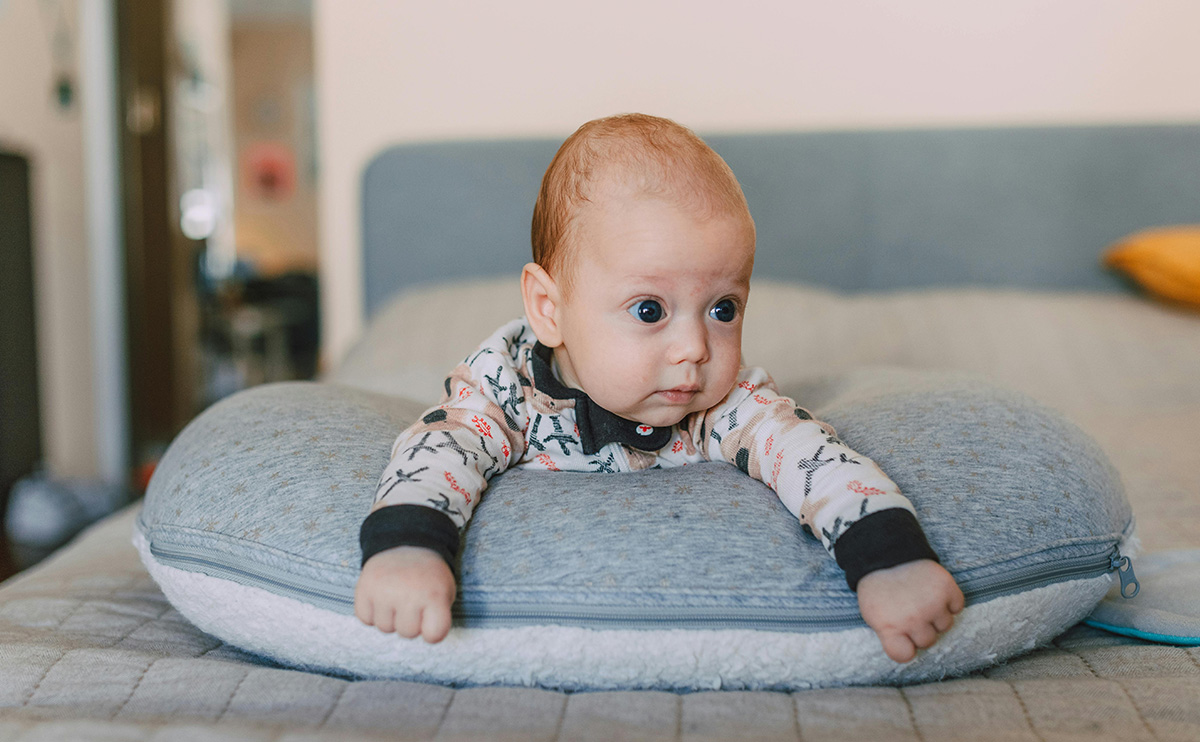 baby having tummy time on feeding pillow